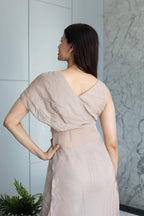 Woman in a light pink dress lying on a marble floor with a white wall in the background