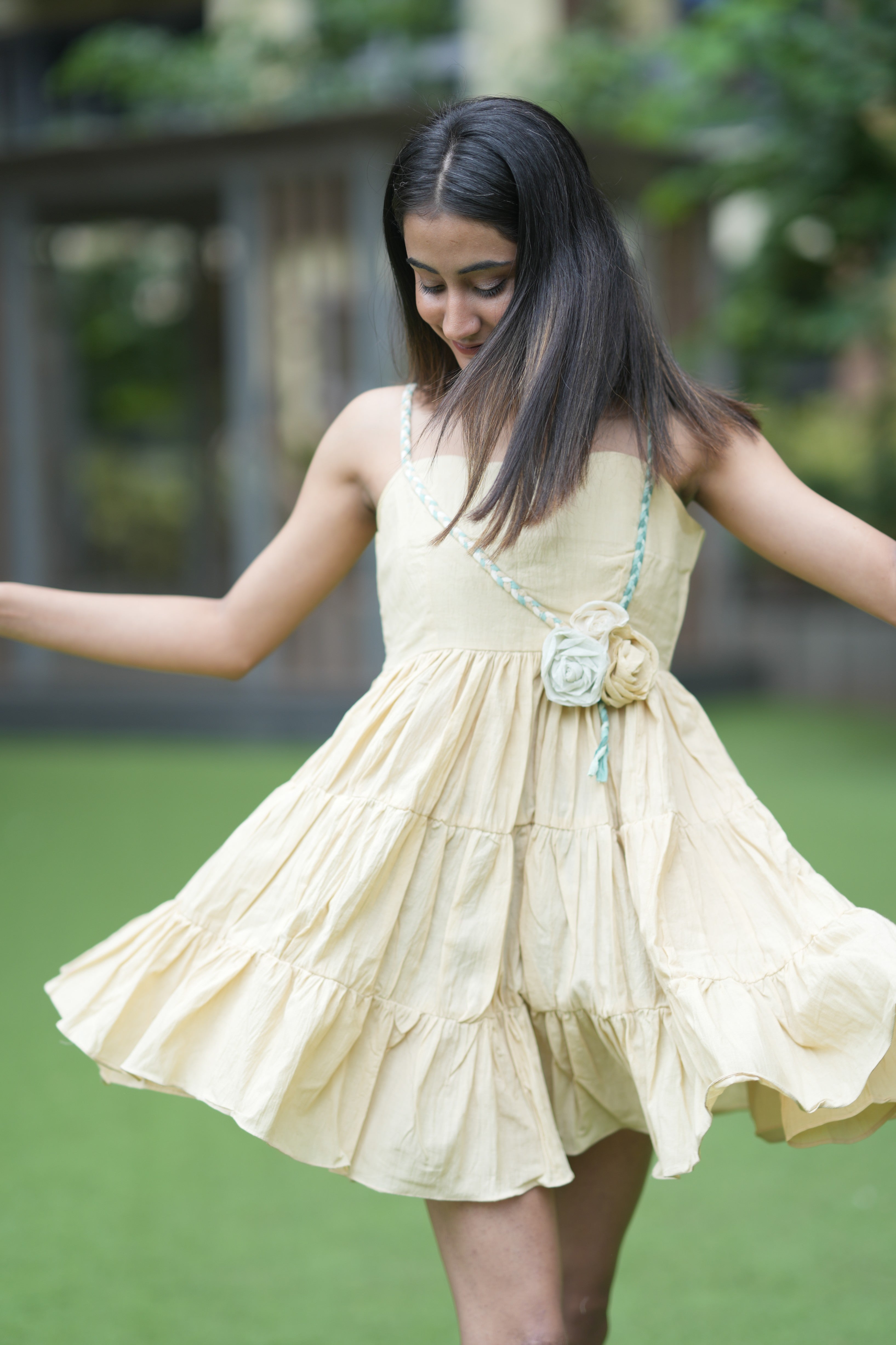 Tiered mustard yellow linen sundress with a braided green and beige strap and small floral embellishment
