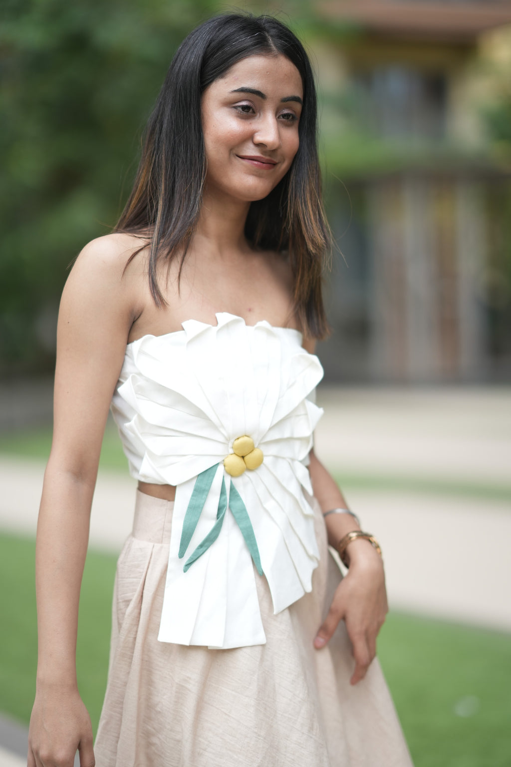 Woman wearing a white strapless dress with floral details outdoors
