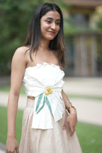 Woman wearing a white strapless dress with floral details outdoors